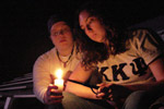 Two friends light a candle at the 2006 Relay For Life event at James Madison University in rememberance of a family member who died from cancer.